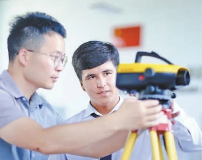 在塔吉克斯坦首都杜尚別的魯班工坊，來(lái)自天津城市建設(shè)管理職業(yè)技術(shù)學(xué)院的老師（左）為當(dāng)?shù)貙W(xué)生提供指導(dǎo)。新華社記者 鄭開(kāi)君 攝