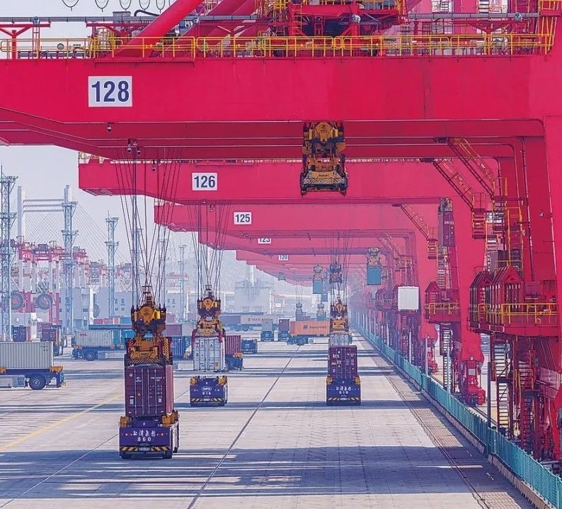 共建“一帶一路”國(guó)家在工作制度對(duì)接、技術(shù)標(biāo)準(zhǔn)協(xié)調(diào)、檢驗(yàn)結(jié)果互認(rèn)等方面強(qiáng)化合作、統(tǒng)一標(biāo)準(zhǔn)，貿(mào)易自由化便利化水平不斷提升。上海洋山港海關(guān)對(duì)接共建國(guó)家進(jìn)出口貨物相關(guān)標(biāo)準(zhǔn)，推動(dòng)通關(guān)一體化方式申報(bào)，提升通關(guān)效率。圖為無(wú)人駕駛的全自動(dòng)導(dǎo)引車(chē)在洋山港穿梭往來(lái)，搬運(yùn)集裝箱。王初 攝