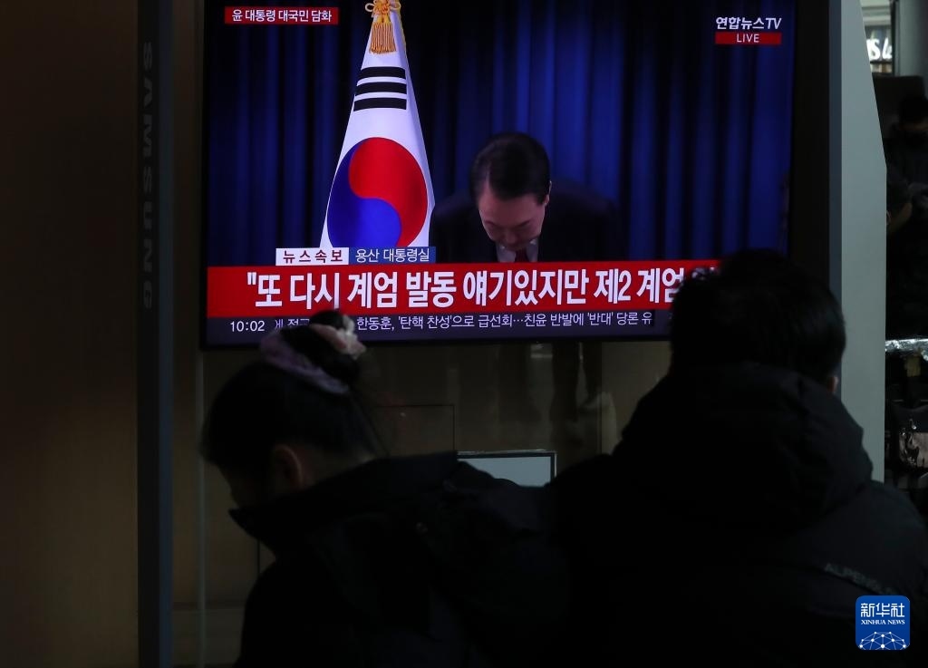 12月7日，在韓國首爾火車站，民眾觀看總統(tǒng)尹錫悅發(fā)表講話的電視畫面。新華社記者 姚琪琳 攝