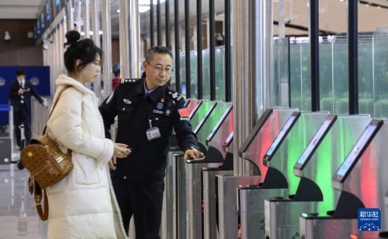 1月2日，大興機(jī)場(chǎng)邊檢站警察指導(dǎo)旅客使用自助出境設(shè)備。新華社記者 李欣 攝
