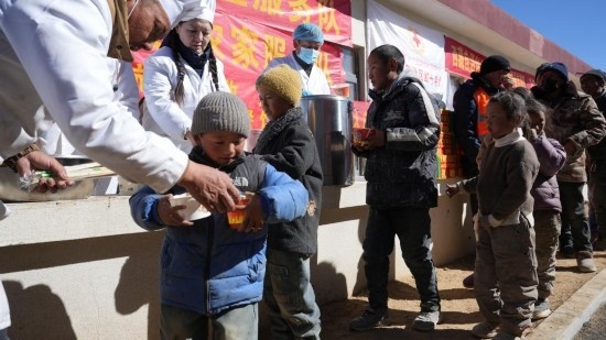 1月14日，廚師們正在給前來用餐的小朋友們打飯。新華社記者 邱星翔 攝