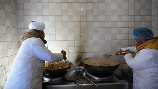 1月14日，服務(wù)隊的兩名廚師正在為村民們做午飯。新華社記者 邱星翔 攝