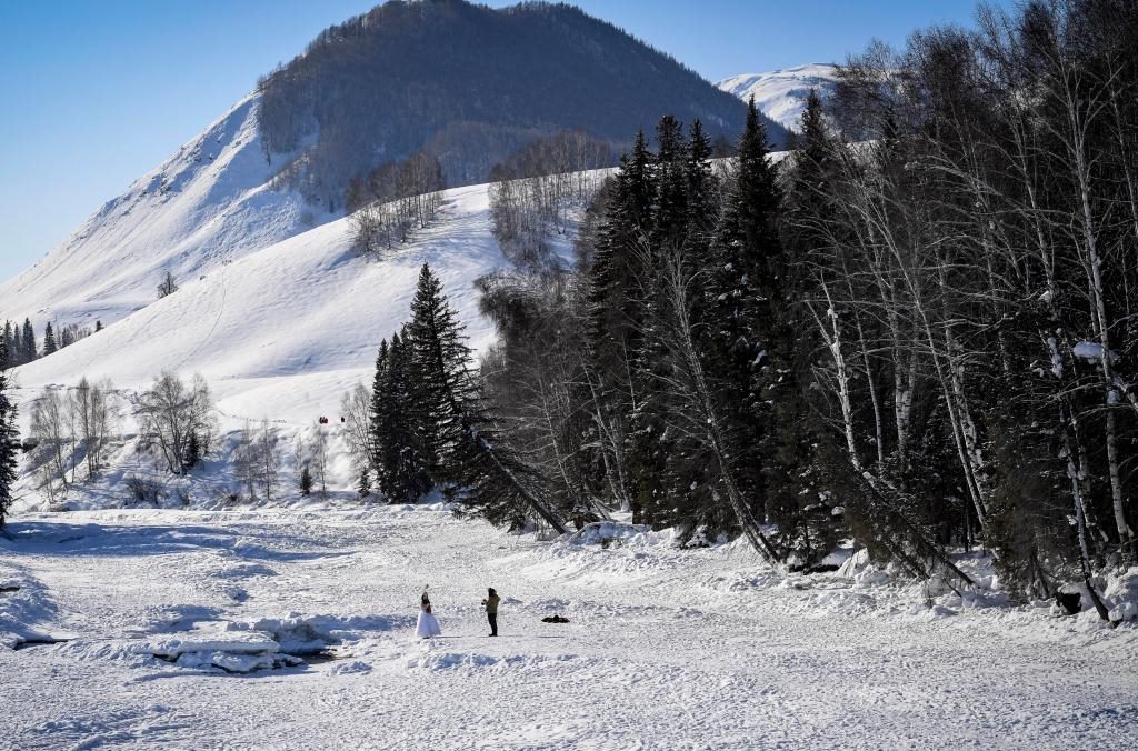 2024年2月5日，兩名游客在新疆阿勒泰地區(qū)布爾津縣禾木村拍照。新華社記者 馬鍇 攝