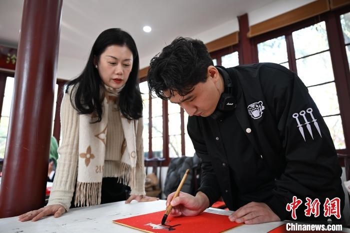 1月20日，外籍留學生在西泠印社社員李硯指導下寫福。當日，來自巴西、馬來西亞、加納、哈薩克斯坦的外籍留學生在浙江杭州西泠印社體驗福貼、春聯(lián)和篆刻，感受古老的中國傳統(tǒng)文化。中新社記者 王剛 攝
