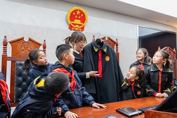 圖②：干警向同學們介紹法袍。