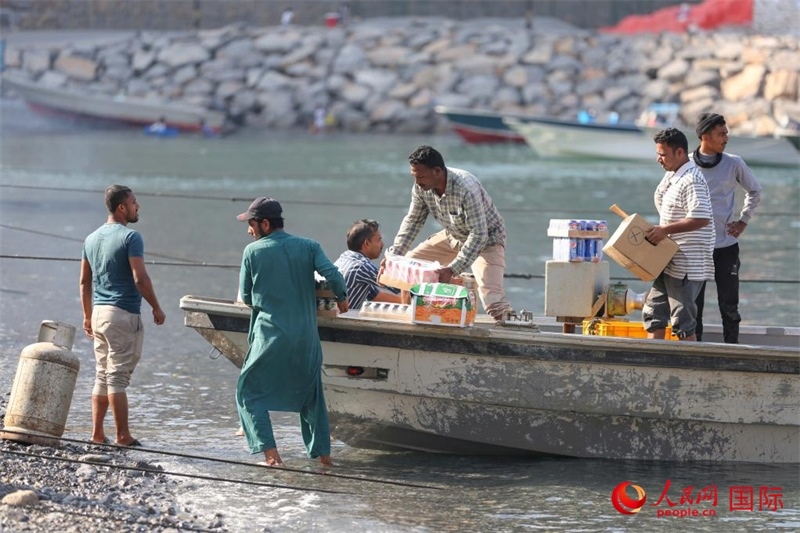 當(dāng)?shù)厝藗冊(cè)谶\(yùn)送生活物資。人民網(wǎng) 塔里克·易卜拉欣攝