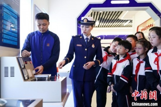 圖為學(xué)生們參觀(guān)道里區(qū)消防救援大隊(duì)消防科普體驗(yàn)館內(nèi)電器火災(zāi)演示實(shí)驗(yàn)臺(tái)。中新社記者 趙宇航 攝