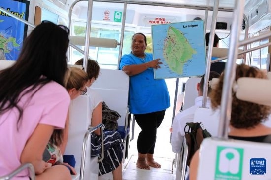 3月15日，一名導(dǎo)游在游艇上為游客介紹塞舌爾拉迪格島。新華社記者 董江輝 攝