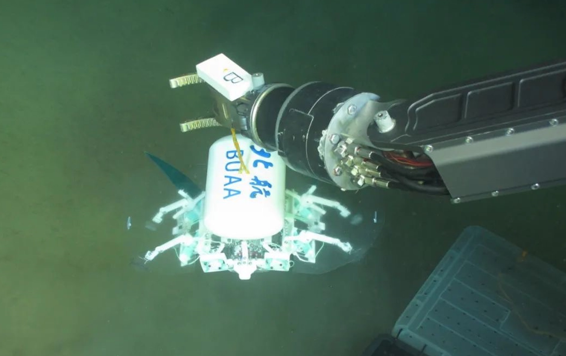 科研人員利用機(jī)械臂將北航深海小型機(jī)器人投于馬里亞納海溝。校方供圖