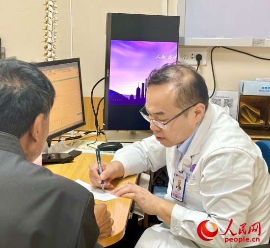 路桂軍接診時為患者寫下用藥提示。人民網(wǎng)記者 金慧慧攝