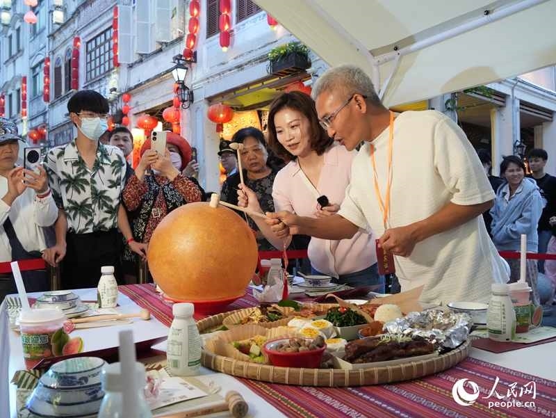嘉賓品嘗海南傳統(tǒng)美食“煎堆”。人民網(wǎng)記者 張力洋攝