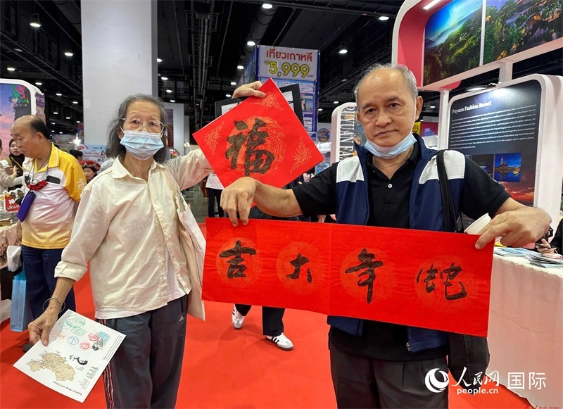 2025蛇年春節(jié)，泰國市民展示他們領(lǐng)到的華人手寫春聯(lián)。人民網(wǎng)記者 簡承淵攝