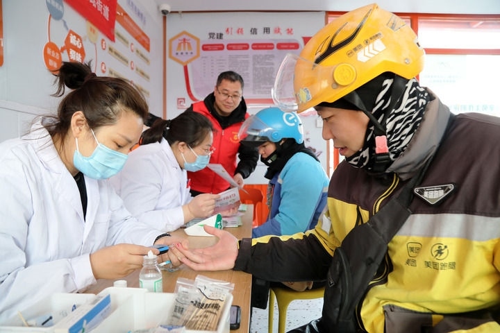 2025年3月5日，志愿者在山東省棗莊市市中區(qū)一工會驛站為外賣員免費測量血糖。新華社發(fā)（王海楠攝）