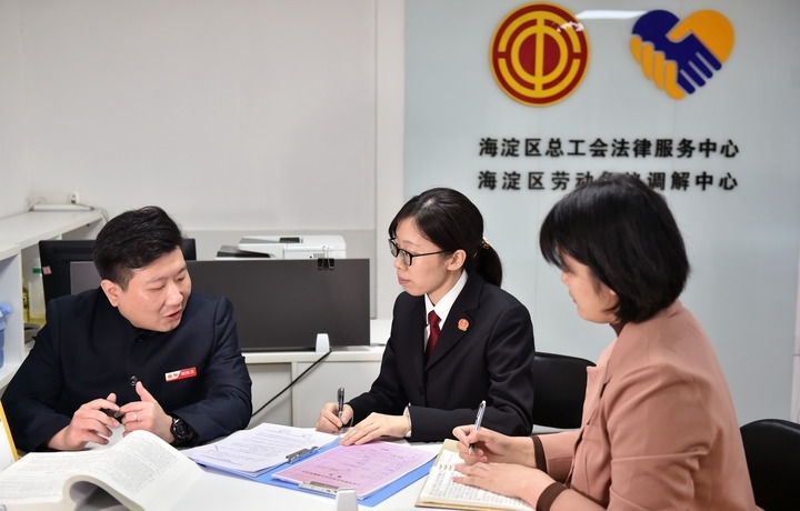2025年3月6日，在北京市海淀區(qū)總工會勞動爭議調(diào)解中心，海淀區(qū)人民法院法官王琰（中）與該中心工作人員就糾紛化解情況進行溝通。新華社記者 趙婷婷 攝