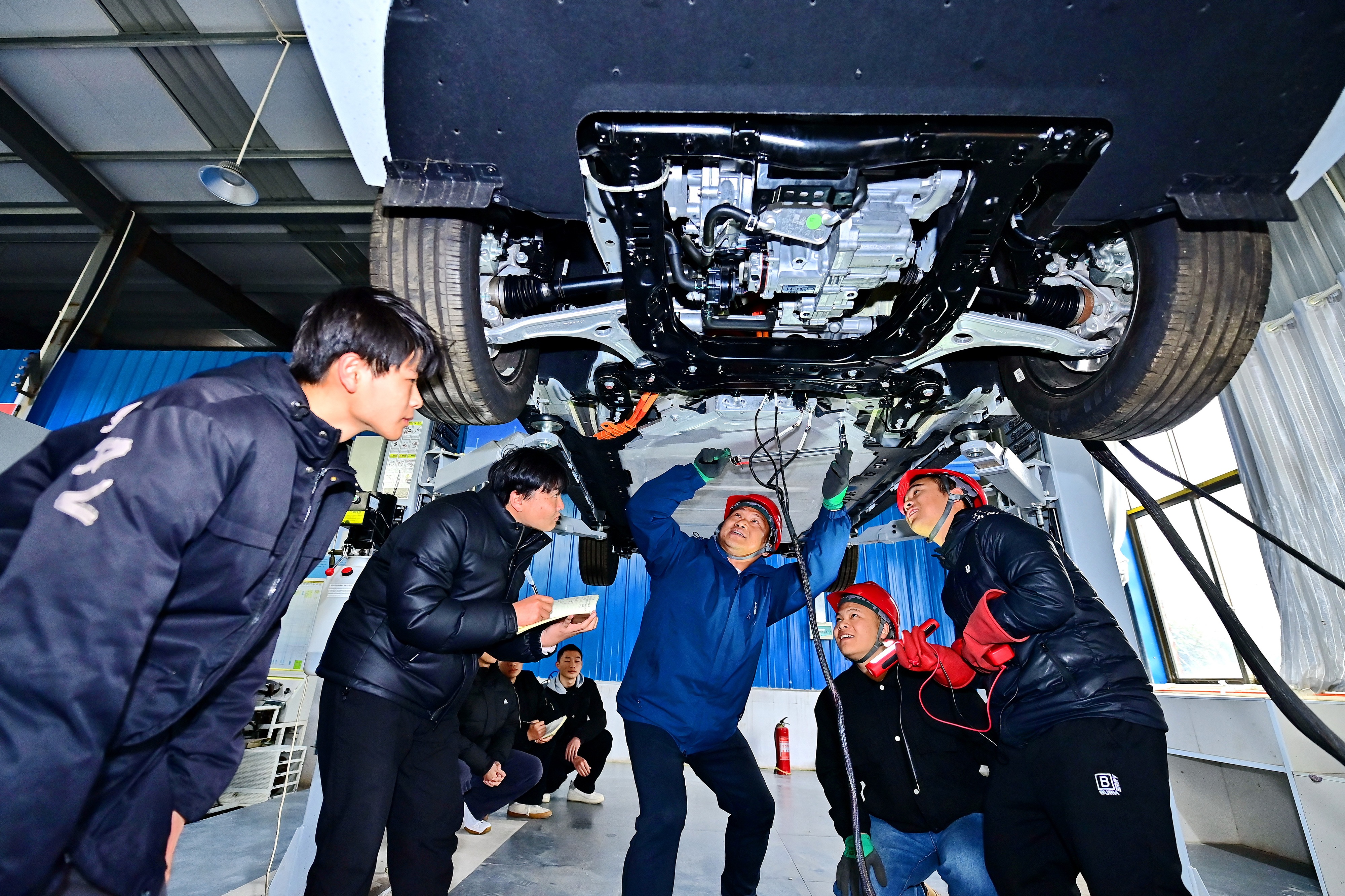 2025年2月，江西省宜春市，豐城市的一所技工學校實訓基地內(nèi)，新能源汽車運維專業(yè)學生在老師的指導下學習新能源汽車電池包檢修技術(shù)。