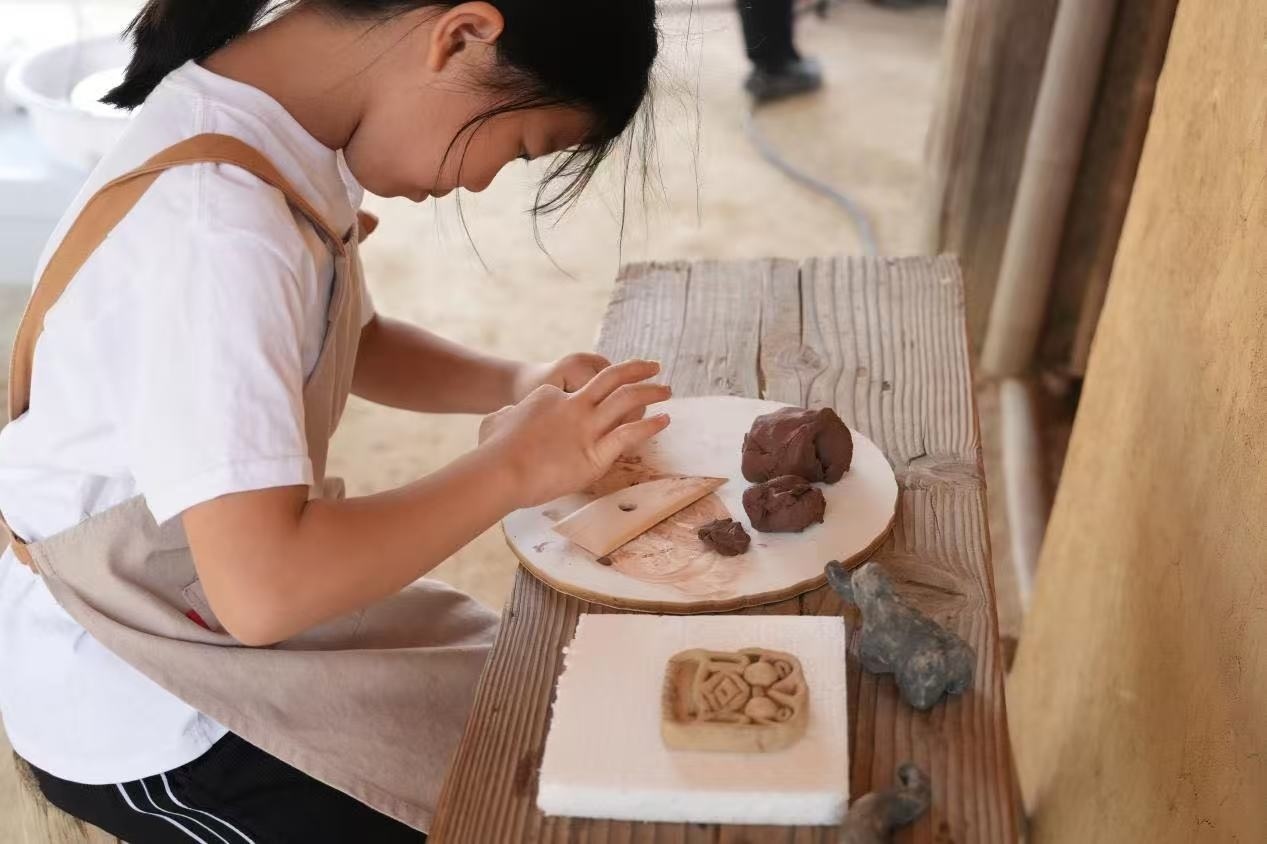 游客制作良渚特色陶藝品。良渚博物院供圖