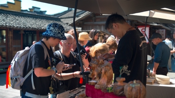 “五一”期間，游客正在烏鎮(zhèn)“水鄉(xiāng)碼頭”挑選購(gòu)買文創(chuàng)產(chǎn)品。受訪者供圖