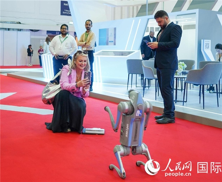 與會(huì)嘉賓被中企機(jī)器人吸引。人民網(wǎng) 塔里克·易卜拉欣攝