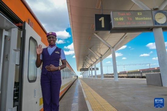 5月31日，在蒙內鐵路內羅畢站，一名乘務員在即將開往蒙巴薩的E2次列車旁等候乘客。新華社記者 楊光 攝