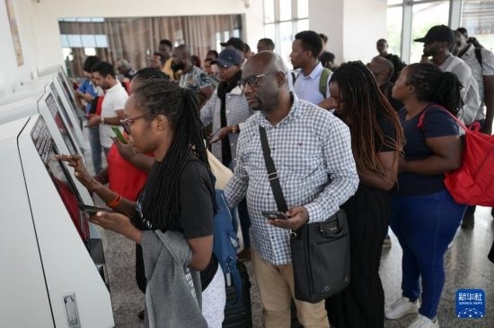 5月31日，在蒙內鐵路內羅畢站，乘客在自助取票機前排隊取票。新華社記者 楊光 攝