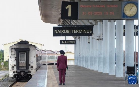5月31日，在蒙內鐵路內羅畢站，工作人員目送開往蒙巴薩的E2次列車駛離站臺。新華社記者 李亞輝 攝