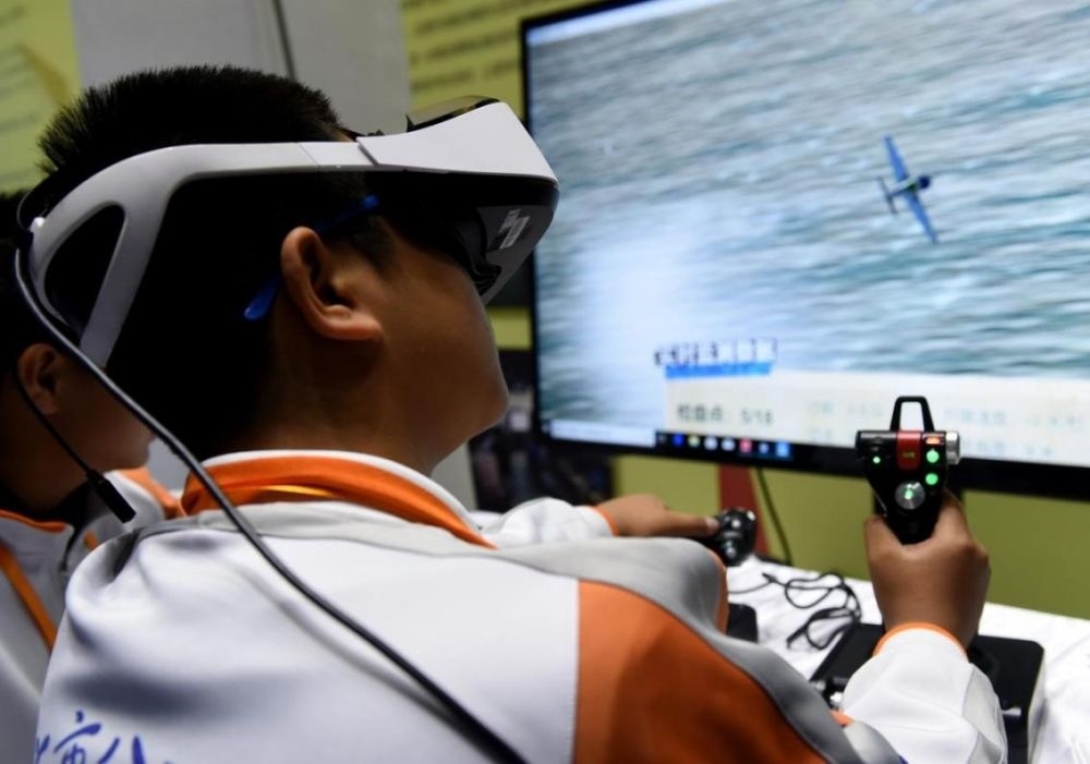 北京市八一學校的學生在北京市中小學生特色科技活動展示上體驗VR技術(shù)（2018年11月24日攝）新華社記者 羅曉光 攝。