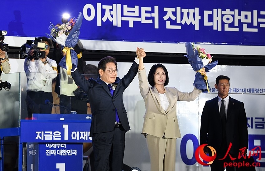 6月4日凌晨，確定當(dāng)選韓國(guó)總統(tǒng)的李在明舉手向歡呼的支持者們致意。 人民網(wǎng) 康炯彬攝